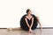 Ballerina in black swan dress against white background. Young ballet dancer practicing before performance in black tutu, classical