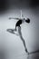 ballerina in a blue bodysuit and ballet shoes poses in a photo studio in motion showing beautiful long legs