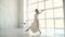 Ballerina dances in a white light dress. ballet dancer in pointe shoes. ease and grace. slow motion