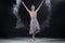 Ballerina dancing in studio with white flour