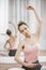 Ballerina With Hand Raised Sitting At Training Studio