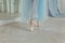 Ballerina hands puts pointe shoes on leg in dance class