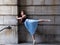 Ballerina in long pleated skirt and pointe shoes standing on fully extended foot