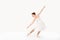 the ballerina in pointes and a dress dances on a white background