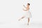 the ballerina in pointes and a dress dances on a white background