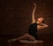 Ballerina Posing in Studio on Brick Background