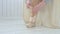 Ballerina puts on pointe shoes on her feet.