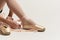 Ballerina puts pointe shoes on her feet White ribbon model dance light background.