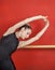 Ballerina Stretching With Hands Raised Against Red Wall