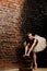 Ballerina in tutu near brick wall