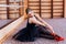 Ballerina Wearing black Tutu Doing exercise in training hall.