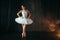 Ballerina in white dress and pointe shoes dancing