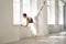 Ballerina. Young graceful ballet dancer is rehearsing a performance in a white class studio