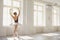 Ballerina. Young graceful ballet dancer is rehearsing a performance in a white studio with windows.