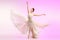 Ballerina. Young graceful female ballet dancer dancing over pink studio. Beauty of classic ballet.