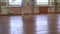 Ballerinas in blue leotards do exercises in pairs during ballet class.