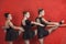 Ballerinas Performing At Barre Against Red Wall