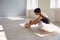 Ballet ballerina. Young girl ballerina dresses pointe shoes sitting on the floor in the studio.