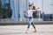 Ballet boy teenager dancing against the background of reflection of the city and sky in the glass wall