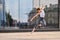 Ballet boy teenager dancing against the background of reflection of the city and sky in the glass wall