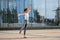 Ballet boy teenager dancing against the background of reflection of the city and sky in the glass wall