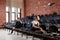 The ballet concept. Young ballerina girls sitting on the black chairs in the hall. Women at the rehearsal in black