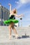 Ballet and Dance Concepts. Happy Smiling Professional Caucasian Ballet Dancer in Green Tutu Dress Posing in Dance On Stairs