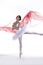 Ballet Dance Ideas. Professional Japanese Female Ballet Dancer Posing in White Tutu With Flying Red Cloth In Hands Against White