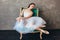 Ballet dancer ballerina in beautiful light blue dress tutu skirt posing sitting on vinage chair in loft studio