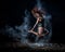 Ballet dancer in black bodysuit jumps high and dance with flour on the beach in the evening. Women`s street ballet