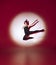 Ballet dancer dancing over red studio background. Modern design. Contemporary colorful conceptual light as rising sun at