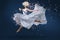 A ballet dancer leaping with grace, adorned in a long white dress and a delicate flower crown. Perfect for conveying elegance,