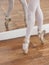 Ballet Dancer Performing Pointe On Wooden Floor