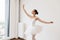 Ballet dancer practice wearing white swan skirt in studio, active lifestyle.