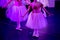 Ballet Dancers under Purple Light with Classical Dresses performing a ballet on Blur Background