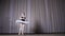 Ballet rehearsal, on the stage of the old theater hall. Young ballerina in white ballet tutu and pointe shoes, dances