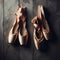 Ballet shoes, old and new, hang on the distressed wall