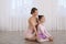 Ballet teacher helping little girl to stretch on floor in dance studio. Space for text