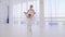 Ballet teacher with little girl training steps on tiptoe in pointes hold hands.