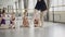 Ballet teacher professional ballerina is dancing on tiptoes demonstrating movements to her little students who are