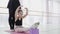 Ballet teacher professional ballerina helping girl stretch legs