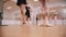 Ballet training - little girls training their stands on pointe shoes with help of their trainer
