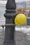 Ballon attached with metal chain to pillar.