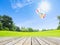 Ballons over wooden floor and green grass