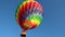 The balloon flies in clear skies. A multi-colored balloon. Aerostat