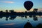 balloon over serene lake, reflection of dawns light