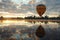 balloon over serene lake, reflection of dawns light