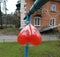 A balloon tied to a blue clothesline in front of an old house