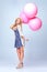 Balloons, fashion and young woman in studio with casual, stylish and cool outfit to celebrate. Excited, happy and full