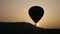 Balloons fly against the sun during sunrise